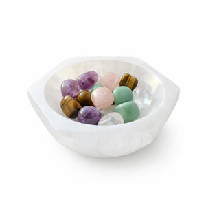 White bowl filled with multicolored stones on a white background